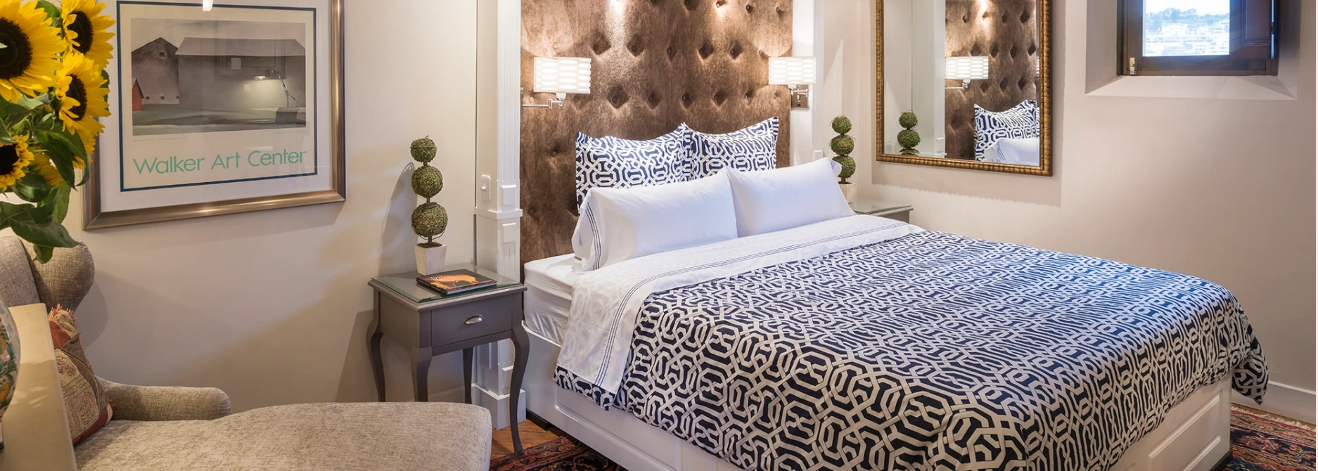 A Villa Colonna suite with a tufted headboard and patterned bedding